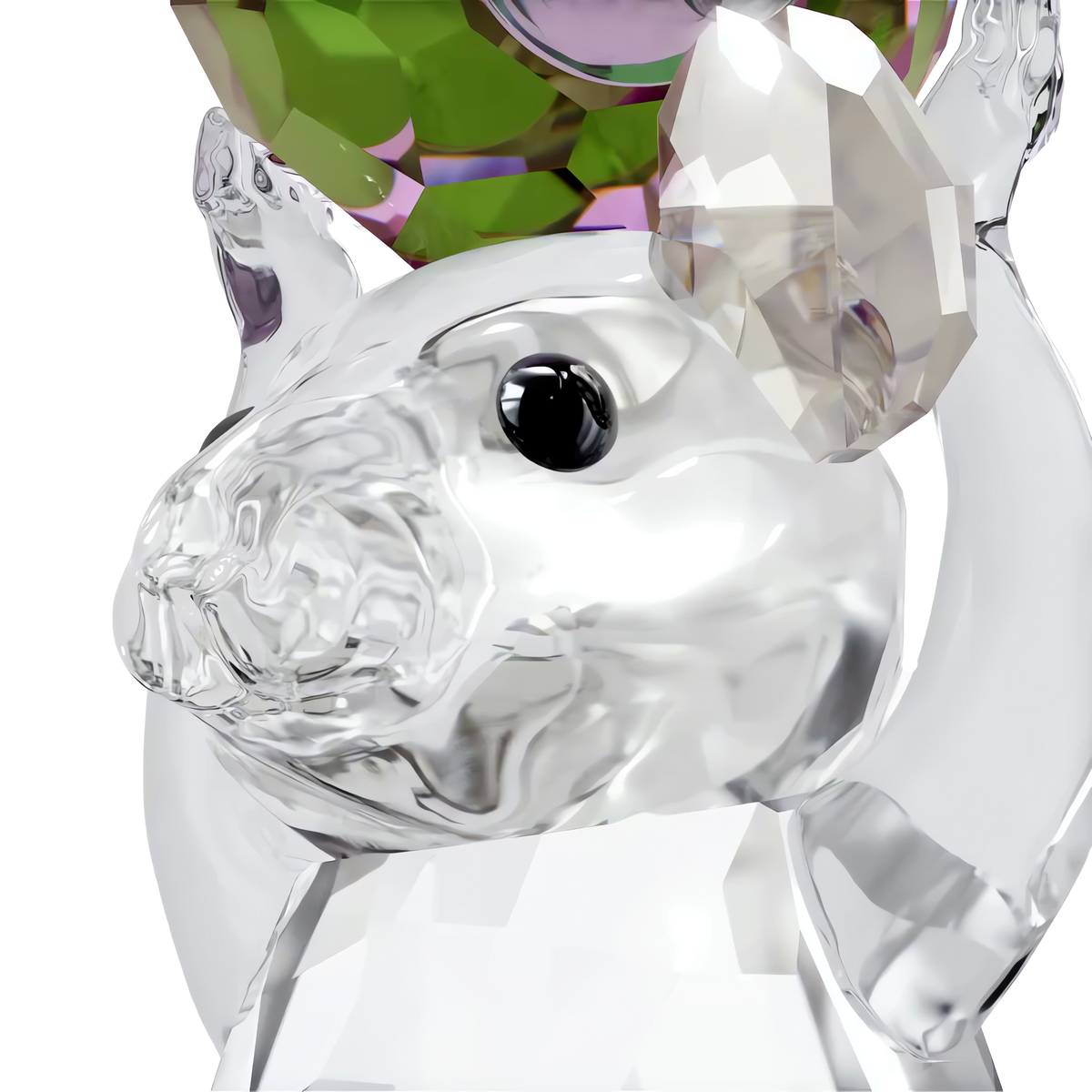 The Swarovski Idyllia Mouse and Radish by Swarovski features a clear glass mouse figurine with one crystal ear, holding a faceted green and purple crystal radish above its head, creating a charming crystal decoration set against a white background.
