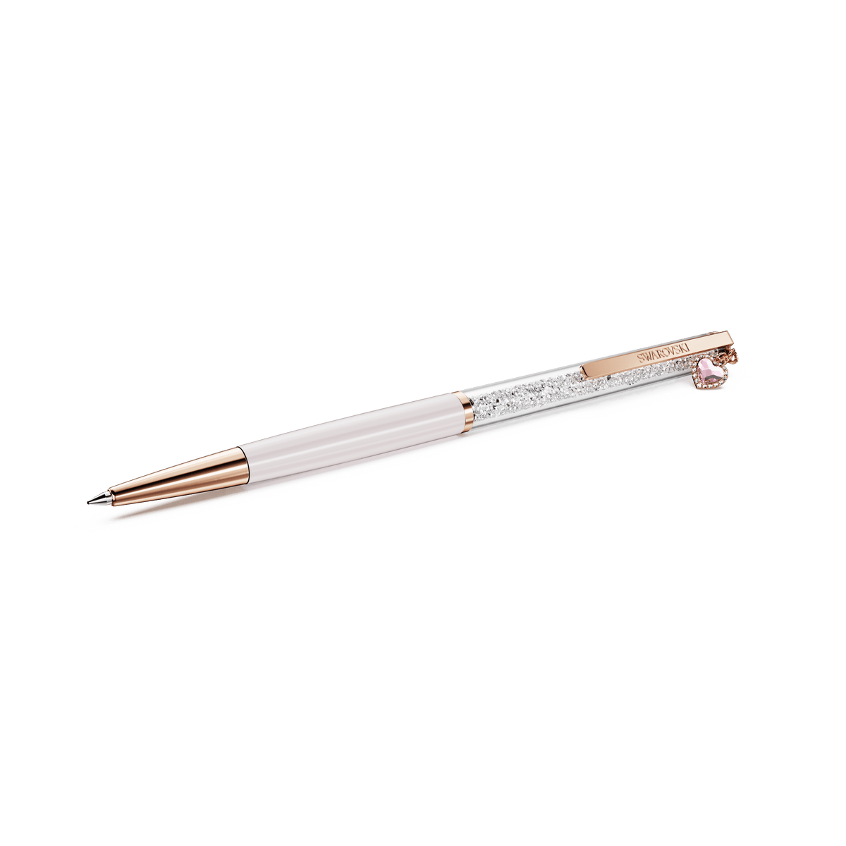 The Swarovski Crystalline ballpoint pen features a pink lacquered and rose gold-tone plated design, with a white barrel, a transparent section filled with sparkling Swarovski crystals, and is adorned with a small pink heart charm near the clip.