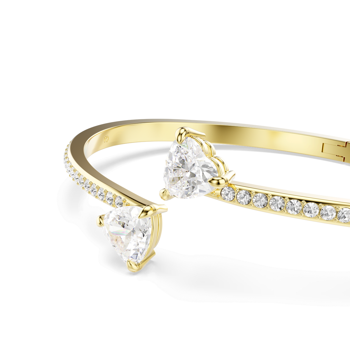 Presenting the Swarovski Mesmera bangle: a breathtaking 18K gold-finished bracelet adorned with two heart-shaped crystals at each end and a row of smaller round stones set along the band, elegantly displayed on a white background.