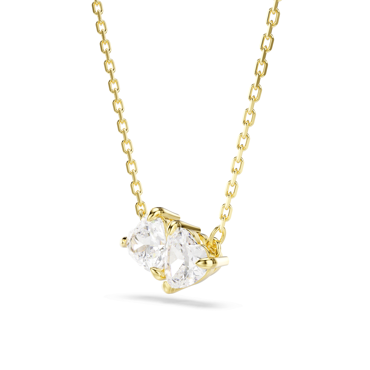The Swarovski Mesmera necklace showcases two clear, heart-shaped stones set side by side in an elegant 18K gold finish against a white background.