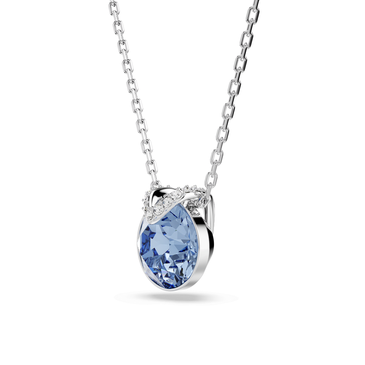 The Swarovski Bella V pendant features a round-cut blue crystal set in a rhodium-plated design, accented by a delicate curved row of clear crystals above the stone for a subtle V-shaped pendant effect, elegantly displayed on a plain white background.