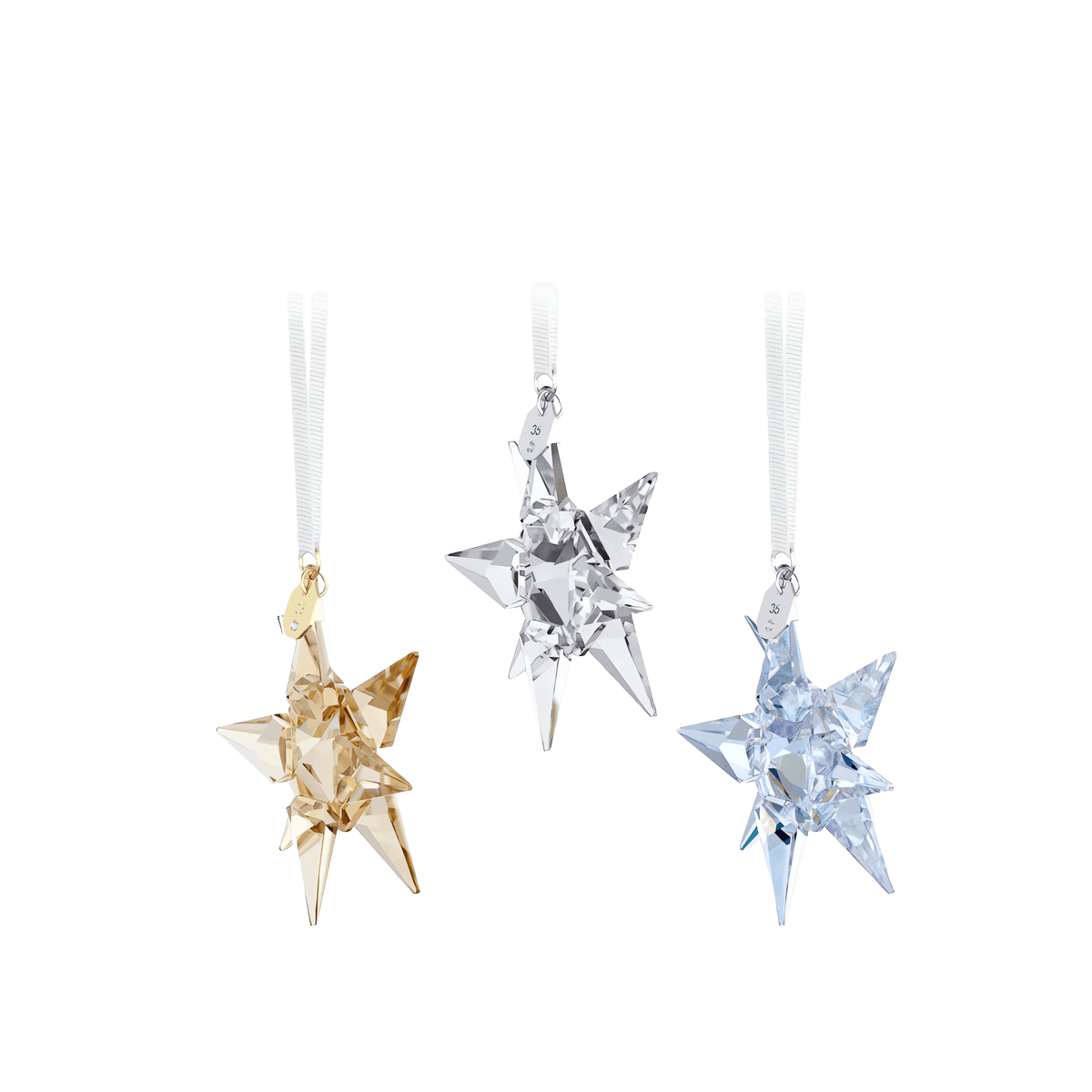 Celebrate the season with the Swarovski Annual Edition 35th Anniversary Ornament Set 2026, featuring three eight-pointed star ornaments inspired by the mesmerizing Aurora Boreale—one in gold, one in clear, and one in light blue—each sparkling like crystal and elegantly suspended from a white hanging ribbon, beautifully presented against a plain white background.