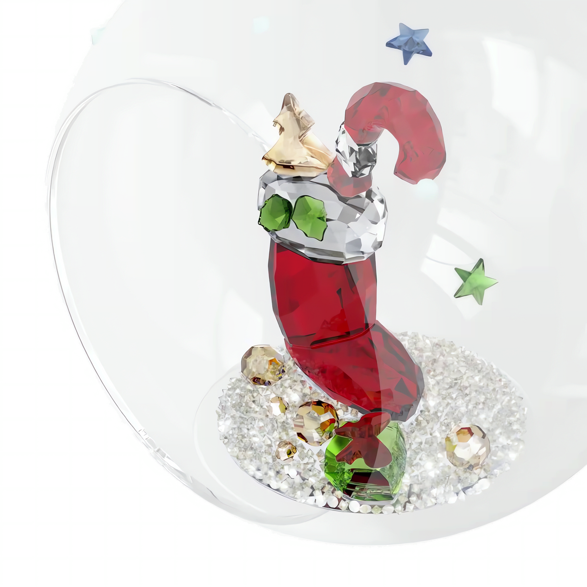 The Swarovski Holiday Cheers Stocking and Candy Ball Ornament by Swarovski features a festive red crystal stocking adorned with green, gold, and silver accents, displayed within a glass holiday ornament and surrounded by star- and round-shaped crystals resting on white beads.
