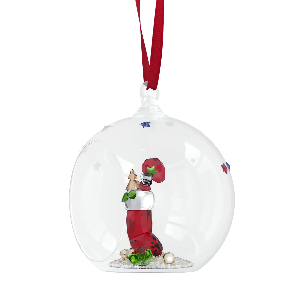 The Swarovski Holiday Cheers Stocking and Candy Ball Ornament by Swarovski features a festive glass globe adorned with a red ribbon, encasing intricate holiday decorations—including a sparkling stocking and candy—resting on white pebbles inside the ornament.