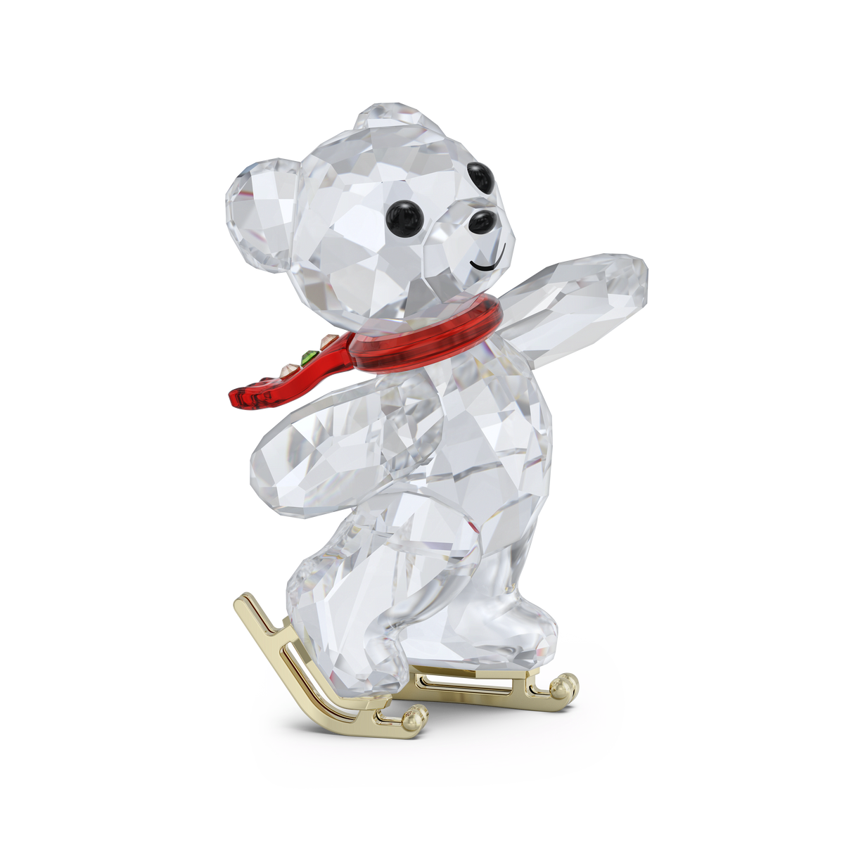 The Swarovski SS Kris Bear 130th Anniversary_SS figurine from the renowned Swarovski brand features a faceted crystal bear with black eyes and nose, adorned with a red scarf and standing on gold-colored skates as if gliding across the ice, set against a plain white background. Available at Raffi Jewellers, your trusted Swarovski Canada retailer.