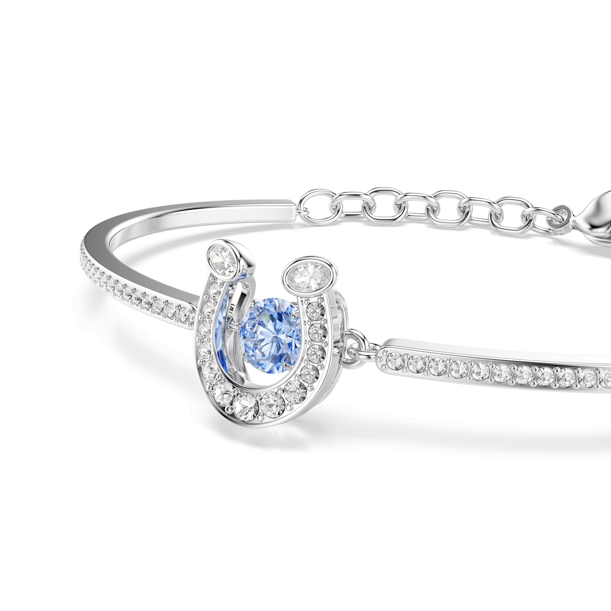 The Swarovski Symbolica bangle by Swarovski is a rhodium-plated bracelet adorned with a horse shoe-shaped charm, featuring a central round-cut blue stone that appears to shimmer, accented by pavé-set clear crystals along the horse shoe and band. The bracelet is displayed on a white background.