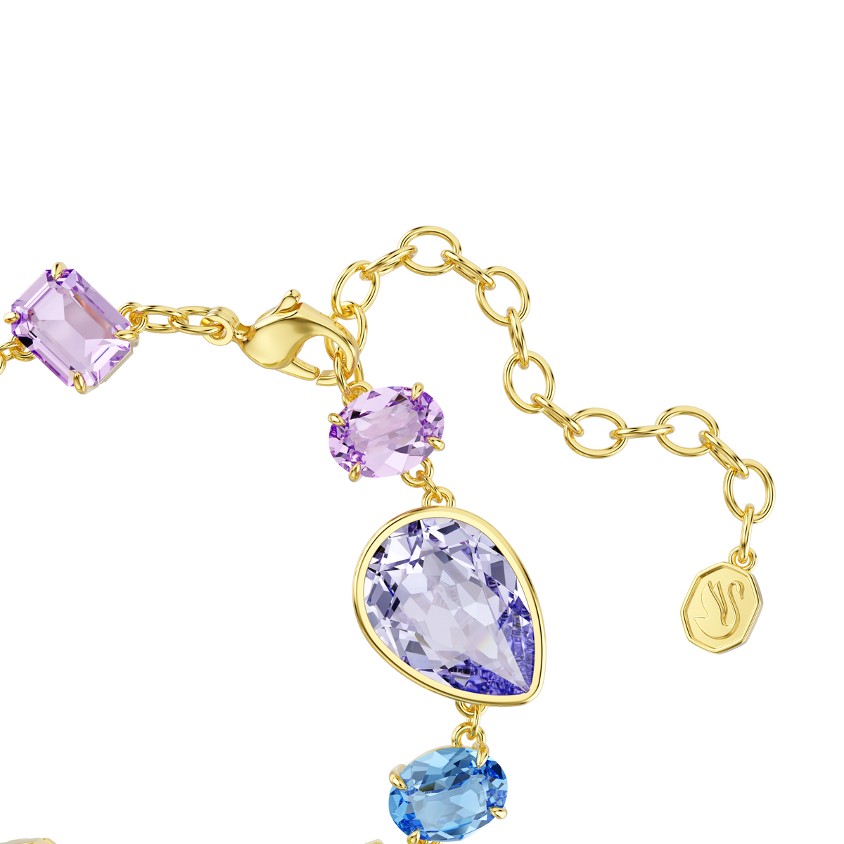 Experience effortless sophistication with the Swarovski Gema bracelet, featuring mixed-cut multicolored crystals in shades of purple and blue set in an 18K gold finish. Accented with a striking teardrop-shaped gemstone and a delicate gold tag, this exquisite bracelet by Swarovski is elegantly displayed on a white background, making it the perfect crystal charm accessory for any occasion.