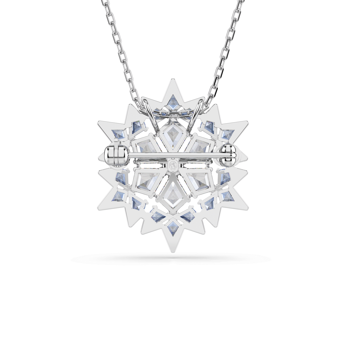 The Swarovski Magic pendant and brooch Snowflake, crafted by Swarovski, features a silver-toned rhodium-plated design shaped like a snowflake and adorned with blue crystals. Suspended from a chain, its elegant form evokes winter’s charm, while the back reveals a horizontal clasp mechanism that allows it to be worn both as a pendant or as a delicate snowflake brooch.