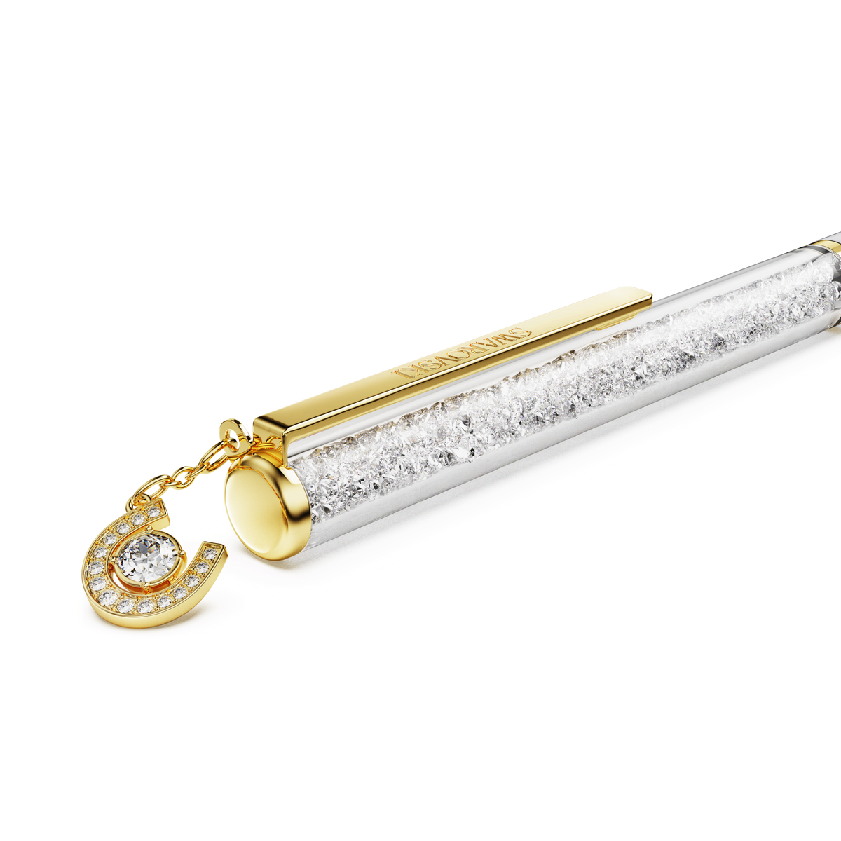 The Swarovski Crystalline Ballpoint Pen features a white lacquered finish, a gold-tone plated clip, a transparent barrel filled with sparkling Swarovski crystals, and is adorned with a dazzling gold-tone horseshoe charm at the end.