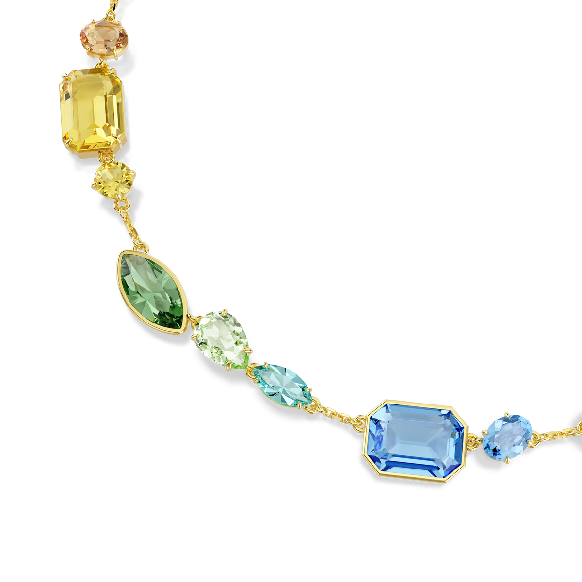 The Swarovski Gema necklace features mixed-cut, multicolored gemstones—including yellow, green, blue, and peach—beautifully arranged in a partial arc and finished with elegant 18K gold plating. Sparkling Swarovski crystals enhance its brilliance, all displayed against a white background.