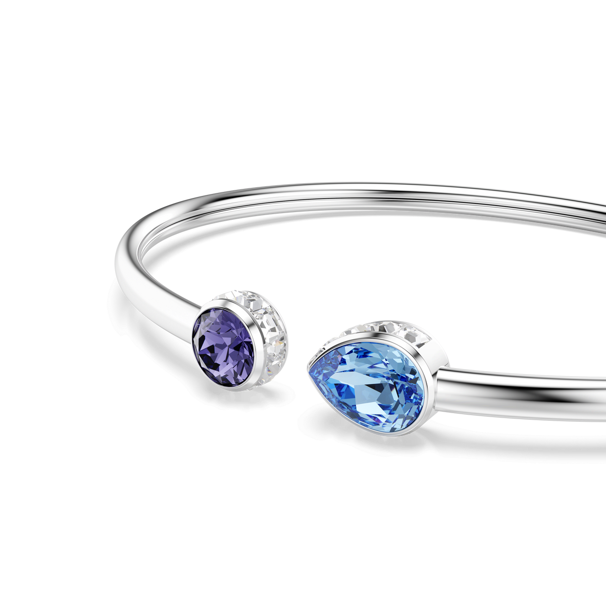 The Swarovski Chroma bangle is a rhodium-plated bracelet featuring mixed-cut gemstones in multicolored hues, including a round purple crystal and a teardrop-shaped blue crystal set at each open end, elegantly displayed on a white background.