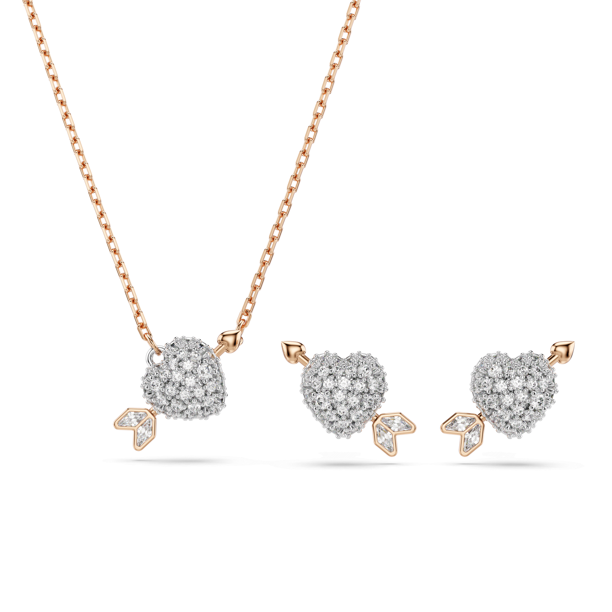 The Swarovski Idyllia set features a heart with arrow design in mixed cuts, adorned with sparkling white stones and beautifully finished in 18K rose gold. This elegant jewelry set, displayed on a white background, includes both a necklace and matching earrings, showcasing the signature craftsmanship of Swarovski.