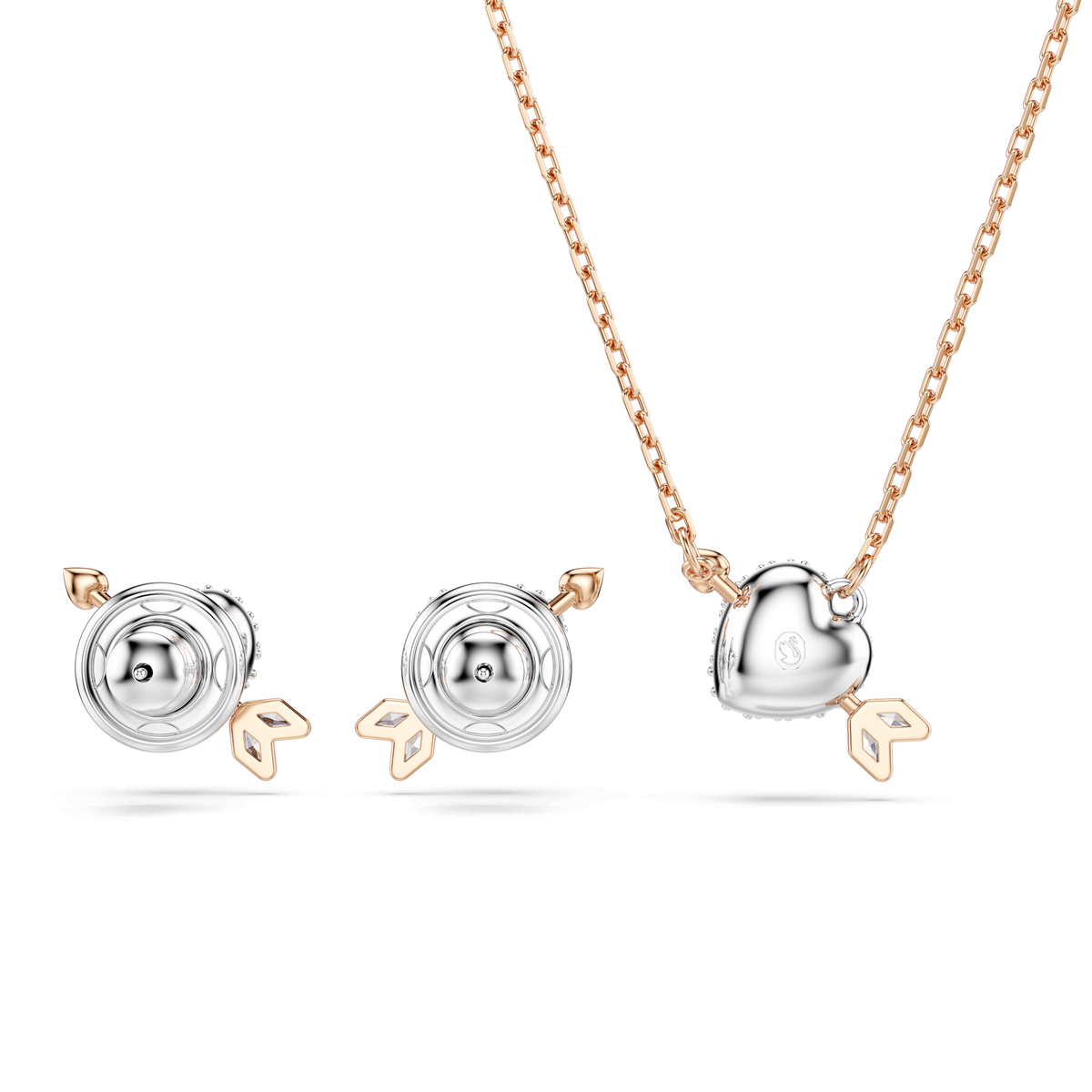 Adorned with a heart-shaped white crystal pendant detailed with an arrow on an 18K rose gold finish chain, the Swarovski Idyllia set by Swarovski also features mixed-cut earrings—each piece elegantly crafted and beautifully presented against a light background.