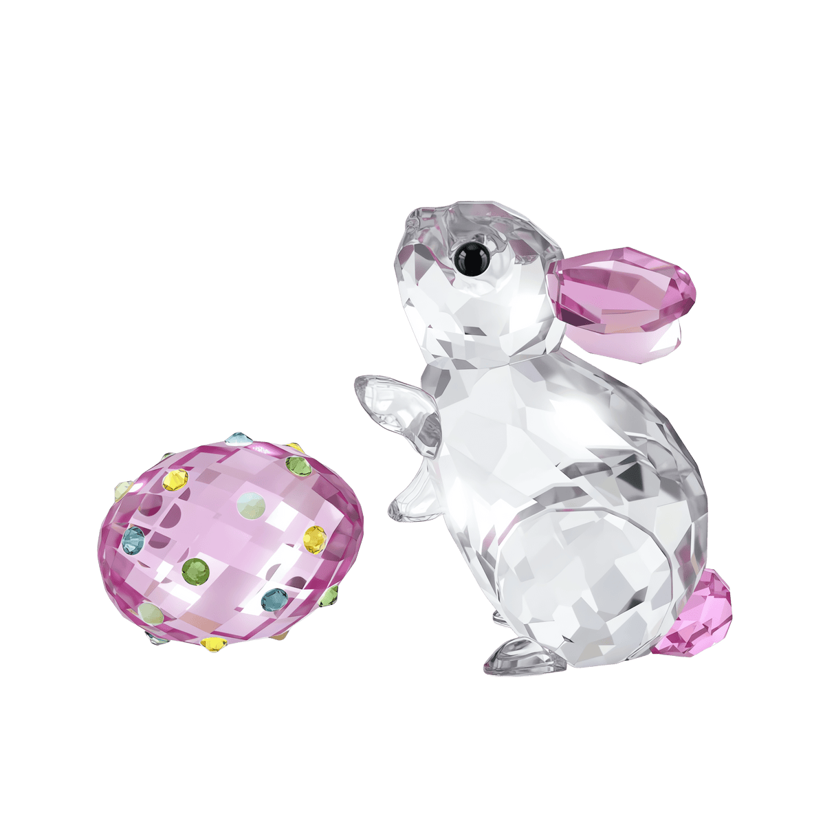 A sparkling creation from Swarovski, the Idyllia Rabbit and Egg features a crystal rabbit with pink ears and tail standing upright beside a pink crystal egg adorned with colorful gems, all set against a plain white background—available at Raffi Jewellers.