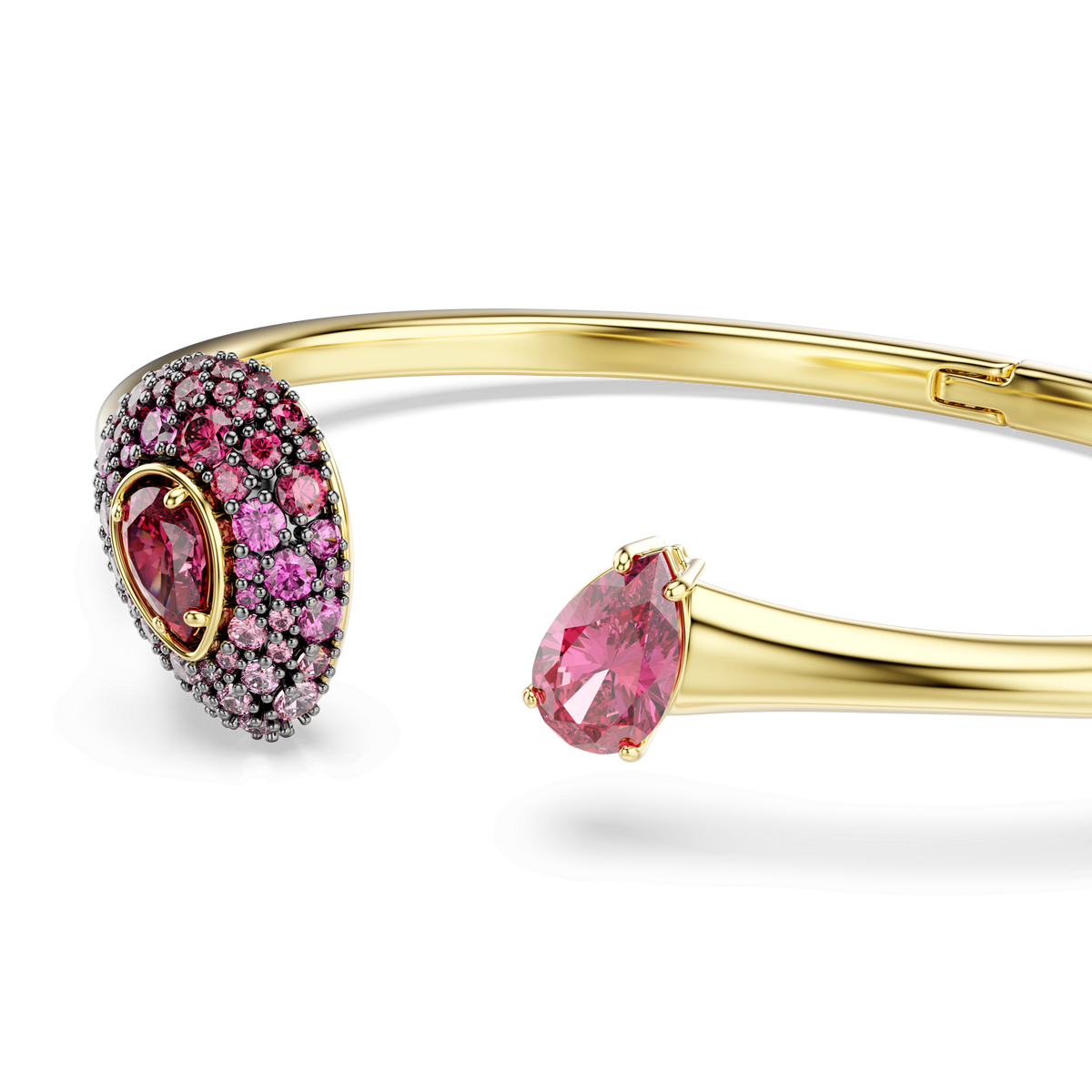 A Swarovski Sublima bangle, featuring a pear-cut red Swarovski Zirconia on one end and a cluster of smaller red stones on the other, is finished in 18K gold and set against a white background.