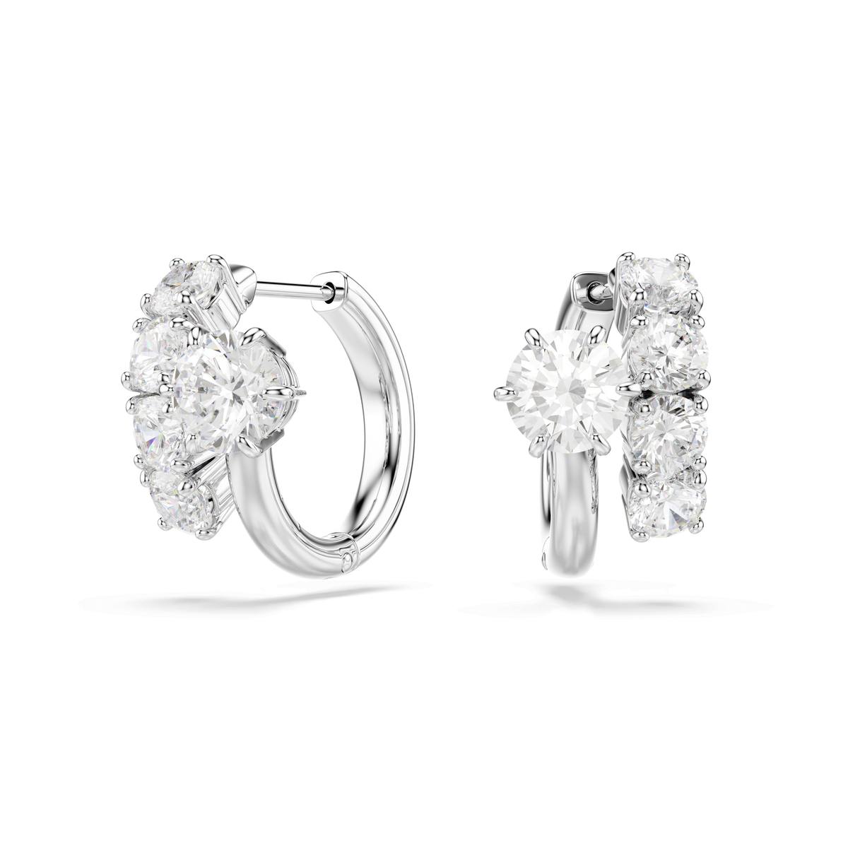 A pair of Swarovski Matrix hoop earrings, crafted from rhodium-plated metal and adorned with five round, white Swarovski Zirconia gemstones arranged in a row on each hoop, with the largest gemstone positioned at the front center.