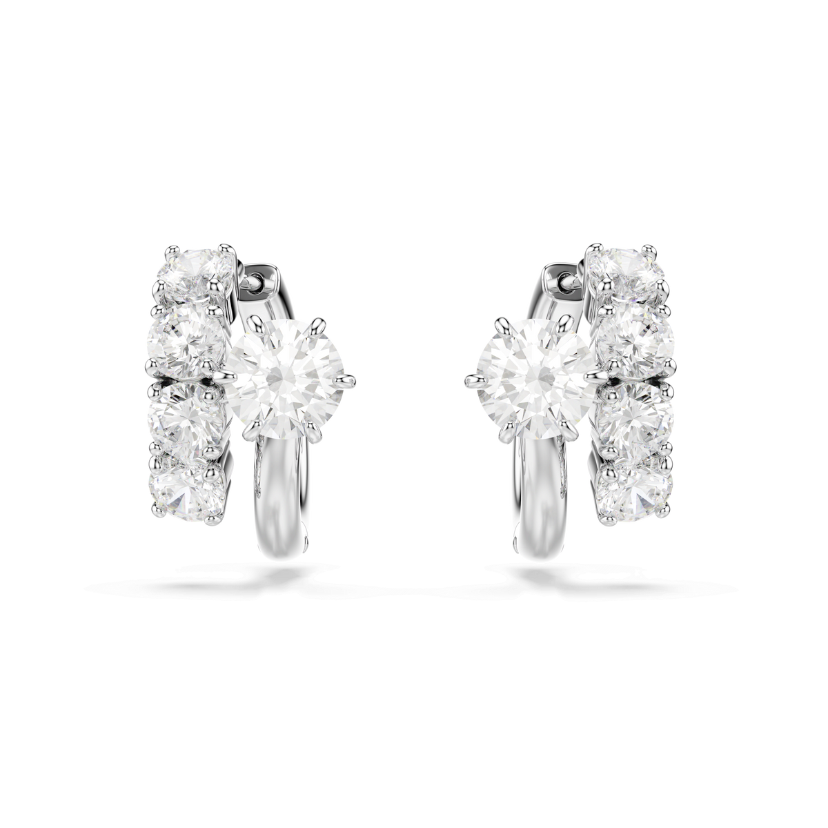 Swarovski Matrix hoop earrings by Swarovski, featuring round-cut clear stones in a subtle helix design and finished with rhodium plating, are displayed against a plain white background.