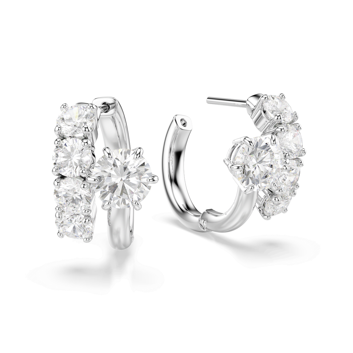 A pair of Swarovski Matrix hoop earrings, crafted in rhodium plating and embellished with multiple round-cut white Swarovski stones—including a prominent central gem on each earring—shown against a white background.