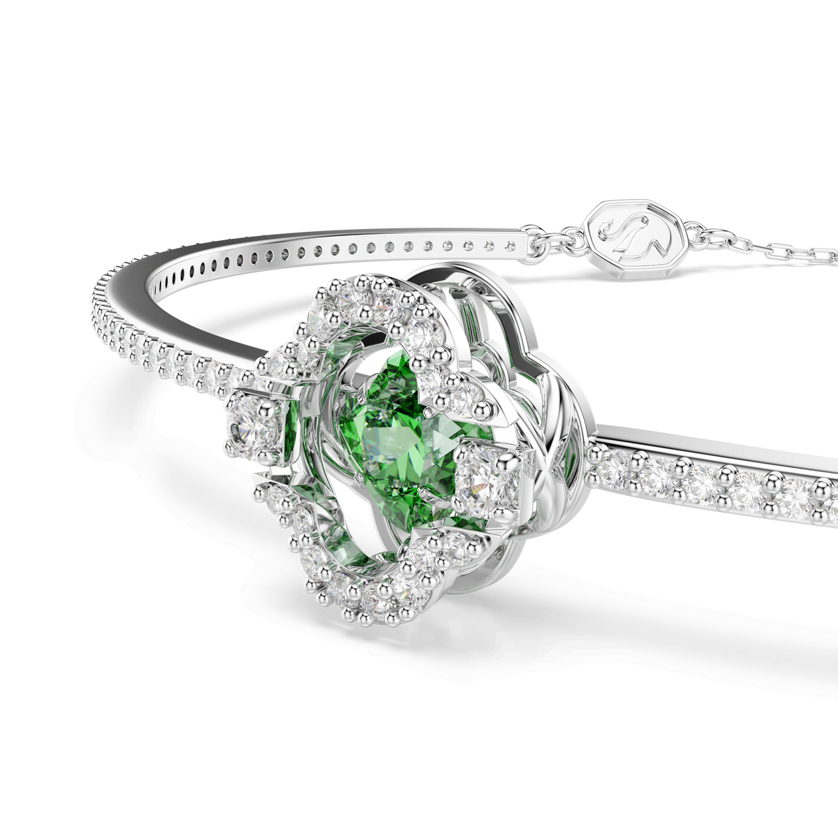The Swarovski Una Angelic bangle, crafted with mixed cuts and a striking green centerpiece, features shimmering clear crystals in a floral-inspired design and is rhodium plated, displayed against a plain white background.