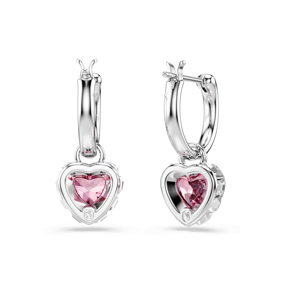 A pair of Swarovski Chroma drop earrings, featuring heart-shaped pink stones set in rhodium-plated frames, are displayed against a plain white background. These elegant Swarovski earrings showcase vibrant pink hearts that add a touch of sparkle and sophistication to any look.