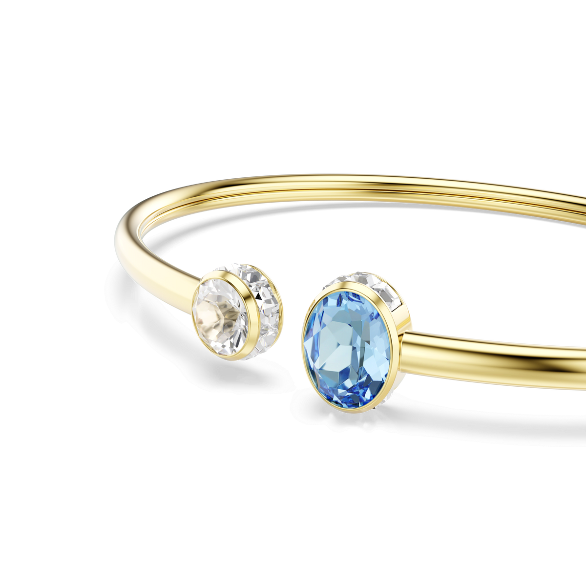 The Swarovski Chroma bangle, crafted with an 18K gold finish, features mixed-cut multicolored Swarovski Zirconia stones—one clear and one blue—each set in round bezels at the open ends of the slender open bangle, shown on a white background.