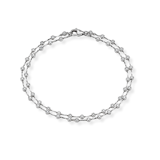 A refined Raffi&Co.® 18K White Gold Diamond Station Necklace, showcasing evenly spaced round brilliant diamond stations along a delicate white gold chain, elegantly presented in a circular arrangement against a plain white background.
