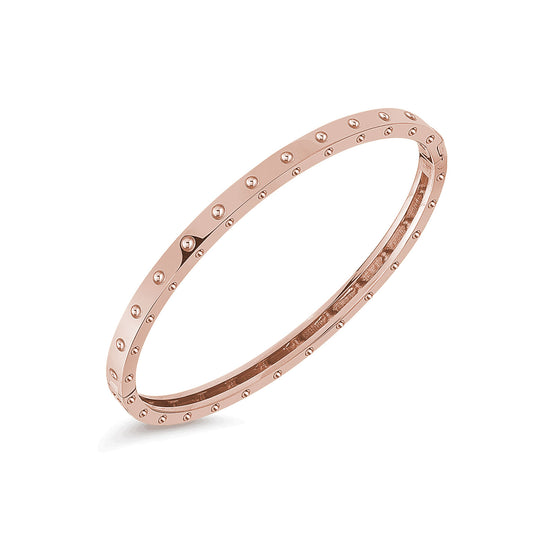 The Roberto Coin Pois Moi 18K rose gold oval bangle, crafted by Roberto Coin, showcases an elegant smooth finish adorned with evenly spaced round studs around its circumference, beautifully set against a white background.