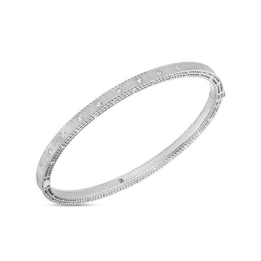 A sophisticated Roberto Coin 18K White Gold Princess Diamond Satin Bangle, featuring small, evenly spaced decorative elements, exudes a minimalist yet elegant charm against a plain white background. Ideal for displaying round diamonds or coordinating with other Roberto Coin accessories.