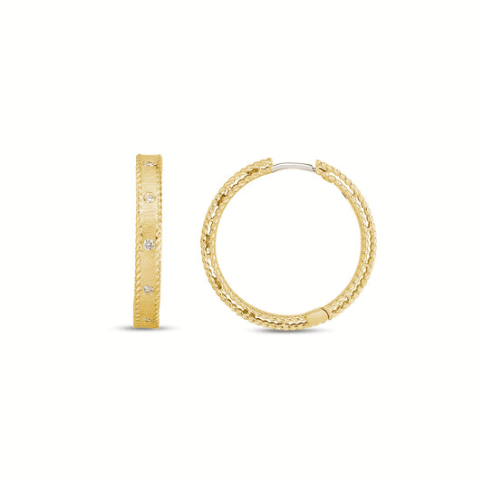 The Roberto Coin Symphony Princess Hoop Earrings by Raffi Jewellers - Canada are pictured: one faces forward, one from the side. The 18K yellow gold hoops display a textured braided design with small gemstones on a plain white background.