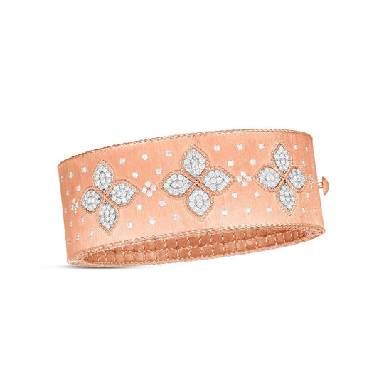 The Roberto Coin Venetian Princess 18K Rose Gold Diamond Bangle is a stunning piece with a wide band that highlights intricate floral designs crafted from small diamonds, offering a textured surface and secured with a side clasp.