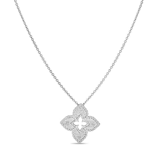 The Roberto Coin Petite Venetian Princess 18K White Gold Diamond Accent Flower Necklace Pendant features a delicate chain with a floral-shaped pendant. Its intricate detailing and symmetrical design add an elegant touch to its minimalist aesthetic. Set against a plain white backdrop, this exquisite piece of jewelry by Roberto Coin becomes a standout accessory.