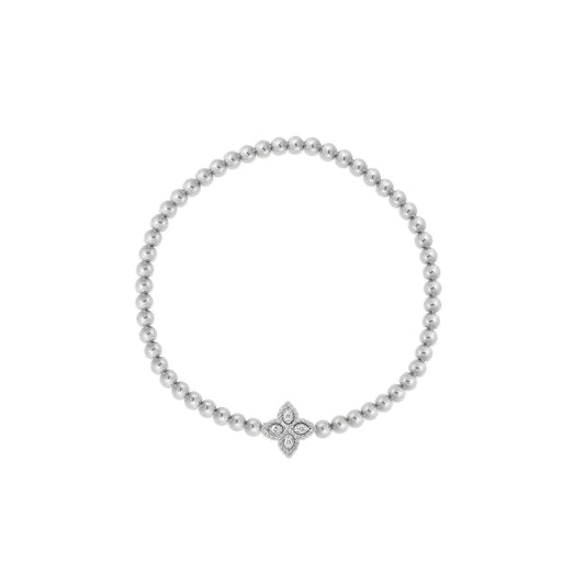 A refined Roberto Coin Petite Princess Flower 18K White Gold Diamond Stretch Bracelet, displaying a small, cross-shaped charm adorned with diamonds in the center. The bracelet features a circle of round beads, creating an elegant and minimalist design by Roberto Coin.