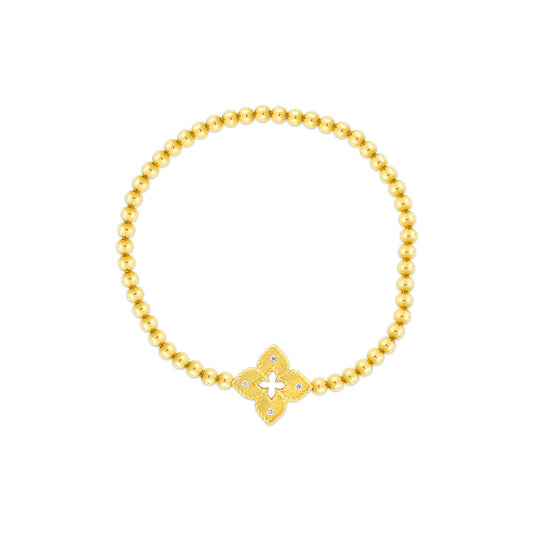 The Roberto Coin Venetian Princess 18K Yellow Gold Diamond Small Flower Stretch Bracelet features a central decorative charm reminiscent of a fleur-de-lis, embodying the refined elegance associated with the Venetian Princess line.