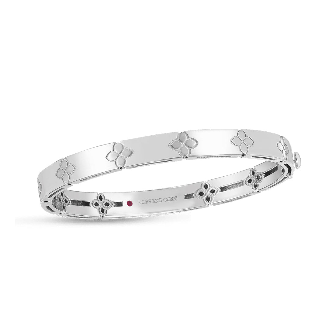 Presenting the Roberto Coin Love In Verona 18K White Gold Medium Width Bangle, a sleek bracelet crafted with a hinged design and adorned with engraved floral motifs. This elegant piece from Roberto Coin features a polished finish and a safety clasp, enhancing its simple and graceful charm.