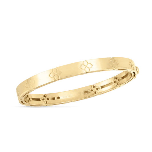 Adorning a pristine white background, the Roberto Coin Love In Verona 18K Yellow Gold Medium Width Bangle showcases a beautiful floral engraving pattern on its shiny surface, with its inner clasp subtly visible.