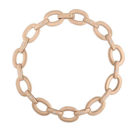 The Roberto Coin Duchessa 18K Rose Gold And Diamond Accent Oval Link Necklace showcases large oval links with a textured surface. Many of these links are embellished with diamond accents, adding a remarkable sparkle to the piece. It elegantly forms a circular shape against a plain white background, embodying the signature sophistication of Roberto Coin designs.