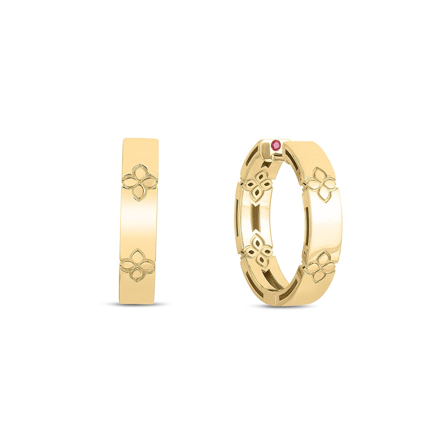 Two huggie earrings made of 18 yellow gold with floral patterns, featuring a small red gemstone on one of them. The design is elegant and minimalistic, showcasing a reflective, polished surface. These earrings are displayed against a plain white background, evoking the timeless style of the Verona Collection by Roberto Coin.