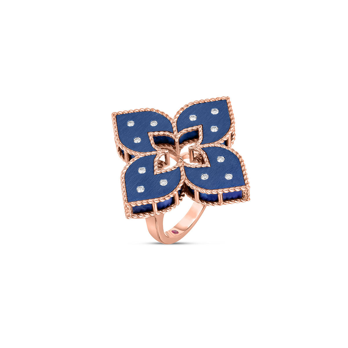 The Roberto Coin Venetian Princess 18K Rose Gold with Large Blue Titanium and Diamond Accent Flower Ring by Roberto Coin features a luxurious and intricate design. It boasts four dark blue titanium petal-like shapes, each adorned with small diamonds that create a symmetrical floral pattern, exuding an aura of elegance and luxury.