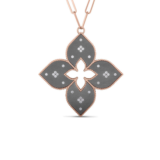 The Roberto Coin Venetian Princess 18K Rose Gold Grey Titanium Pendant is a stunning addition to any jewelry collection, featuring a quatrefoil design with black inlays and small white gemstones arranged in symmetrical patterns.