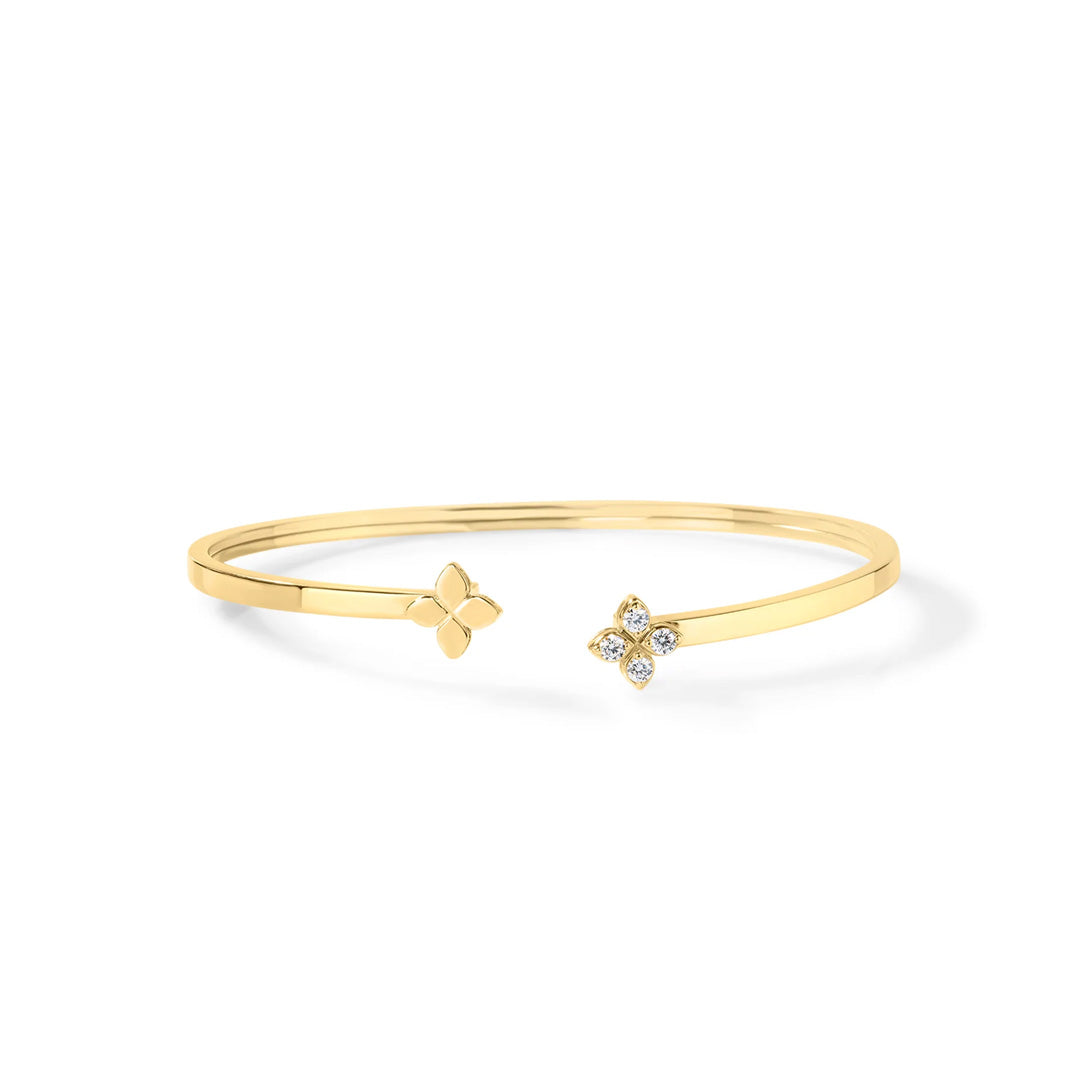 The Roberto Coin Love in Verona 18K Yellow Gold Diamond and Polish Flower Cuff Bangle is an exquisite open bracelet featuring one end adorned with a sleek, polished four-petal flower and the other end showcasing a dazzling diamond flower motif, beautifully accented with delicate sparkling stones that enhance its floral design.