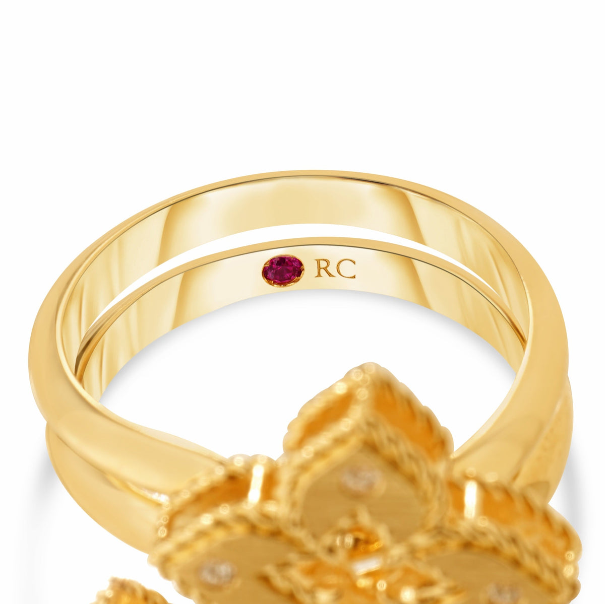 Roberto Coin Venetian Princess 18K Yellow Gold Diamond Ring featuring a flower-shaped setting with a small red gemstone and “RC” engraved on the inner band.