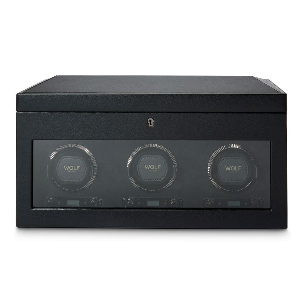 Introducing the WOLF 1834 British Racing Triple Watch Winder With Storage: a stylish black winder featuring three circular compartments within a sleek rectangular case. Each compartment proudly bears the "WOLF" insignia and includes a transparent front panel. This patented design offers multiple rotation options, ensuring your automatic watches are perfectly wound.