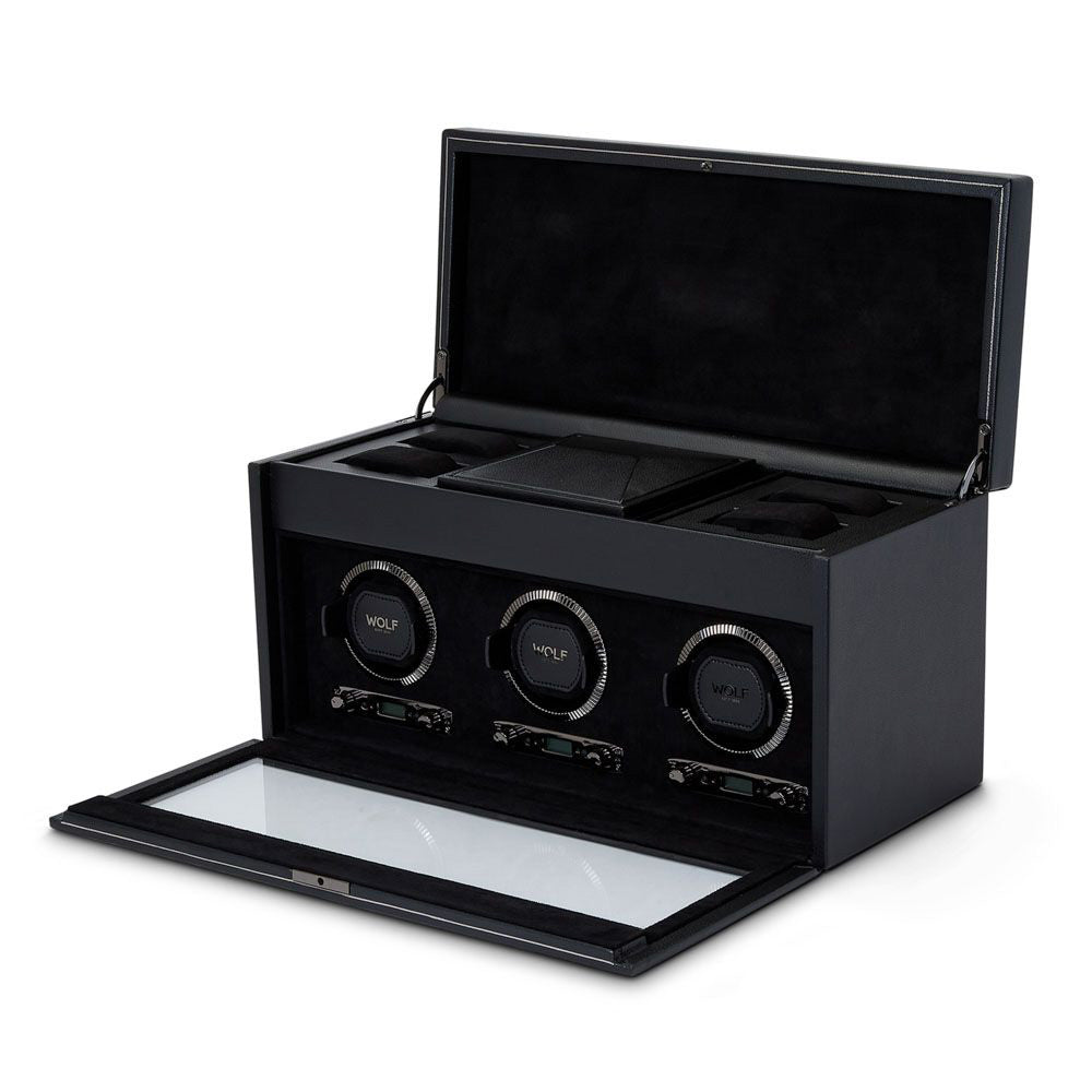 The WOLF 1834 British Racing Triple Watch Winder With Storage is an elegant black watch winder box that prominently displays three circular holders, each marked with the "WOLF" logo, and utilizes patented technology for ideal rotation settings. Its open lid reveals extra storage compartments, all lined with a luxurious black material.
