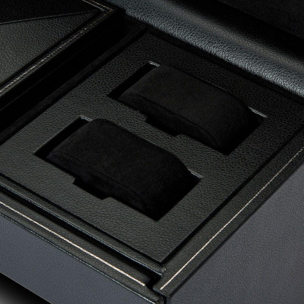 Close-up of two black watch cushions inside the WOLF 1834 British Racing Triple Watch Winder With Storage, featuring a sleek, textured storage box with patented lock-in. The interior boasts an elegant design with sharp lines and a luxurious finish, perfectly complementing its sophisticated rotation options.