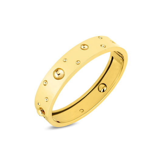 The Roberto Coin Pois Moi Luna 18K Yellow Gold Medium Width Bangle is crafted from 18 Karat yellow gold with a polished finish and features evenly spaced, raised circular rivet-like details, showcasing an elegant, minimalist design.