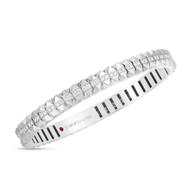 The Roberto Coin Obelisco 18K White Gold Fiamond Hinged Petite Bangle features a sophisticated geometric design with a single row of square-cut diamonds, subtly accented by a small red gemstone, embodying the elegance for which Roberto Coin is renowned.