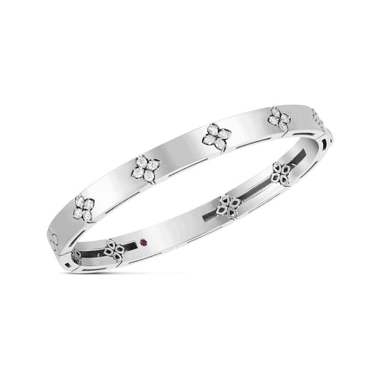 The Roberto Coin Love In Verona 18K White Gold Medium Width Diamond Accent Bangle beautifully captures Roberto Coin's signature elegance with its sleek design, featuring floral-shaped diamond accents evenly spaced around its surface.