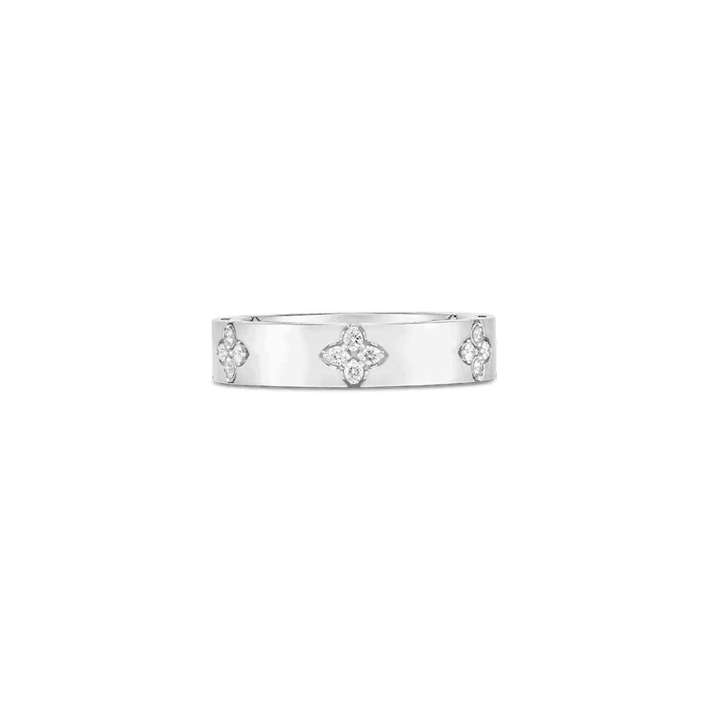 The Roberto Coin Love In Verona 18K White Gold Diamond Ring features a smooth band adorned with evenly spaced flower-shaped diamond settings. Designed in a classic style, the ring embodies simplicity and elegance, reflecting the signature touch of Roberto Coin.