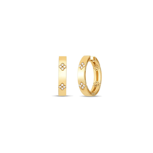 The Roberto Coin Love In Verona 18K Yellow Gold Diamond Huggie Earrings, crafted by the renowned brand Roberto Coin, feature round diamonds with SI1-SI2 clarity. These elegant earrings are adorned with small diamond-accented floral patterns that are evenly spaced around the hoops, showcased on a plain white background to highlight their gleaming finish and sophisticated design.