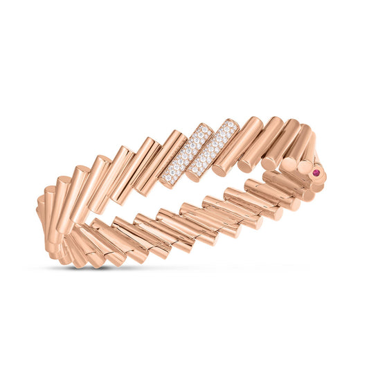 The Roberto Coin Domino 18K Rose Gold Diamond Accent Large Bangle, inspired by the brand's sophisticated designs, showcases cylindrical links highlighted by a section adorned with small, sparkling diamonds. Its flexible spiral form is beautifully complemented by a round pink gemstone detail, making it a stunning piece to treasure.